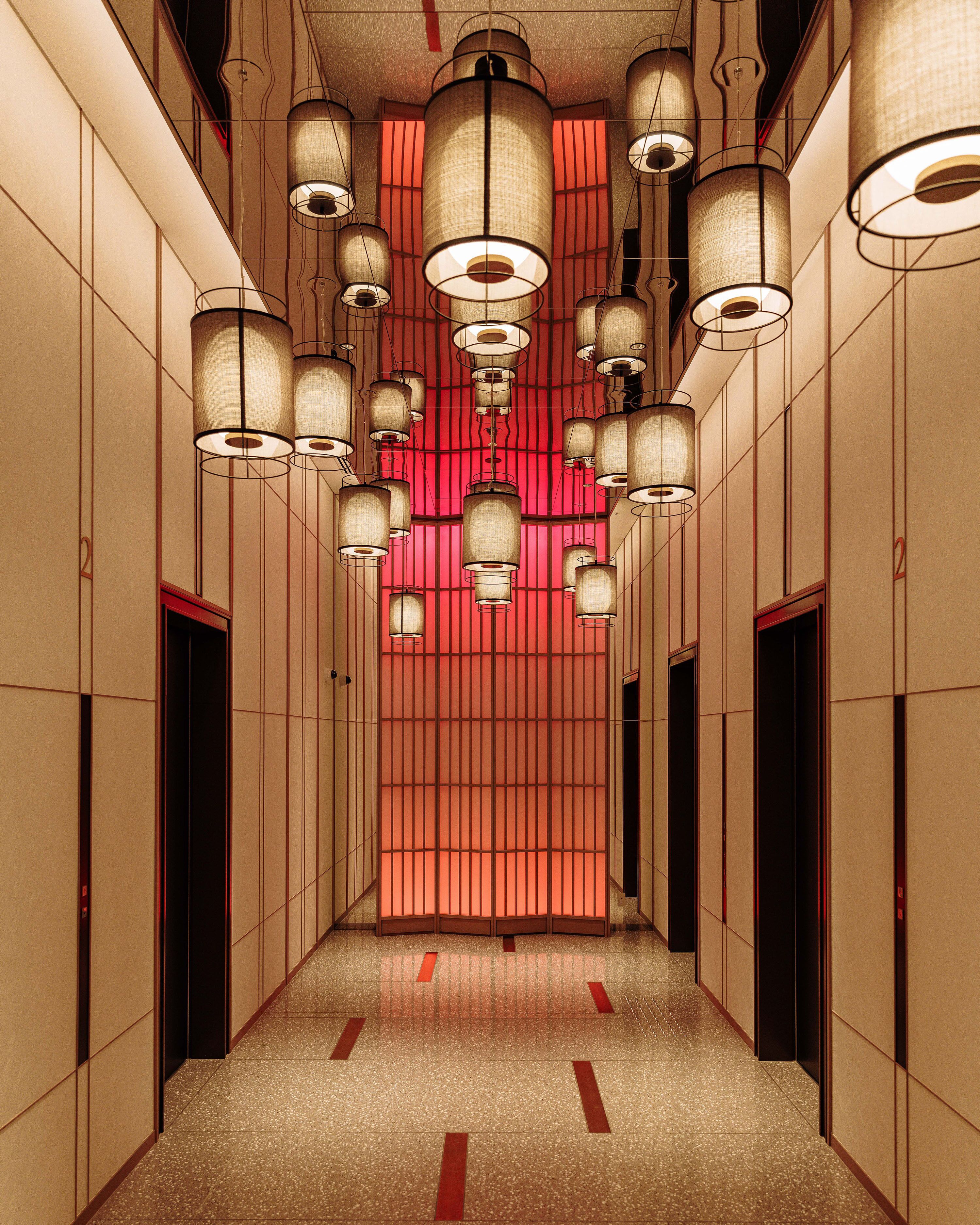 A corridor with multiple doors and hanging lamps.