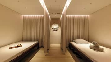 Une chambre d’hôtel avec deux lits simples, un plancher en bois et un élément décoratif au centre du mur.