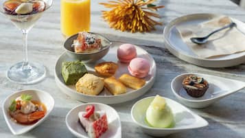 A variety of desserts and beverages on a marble table.