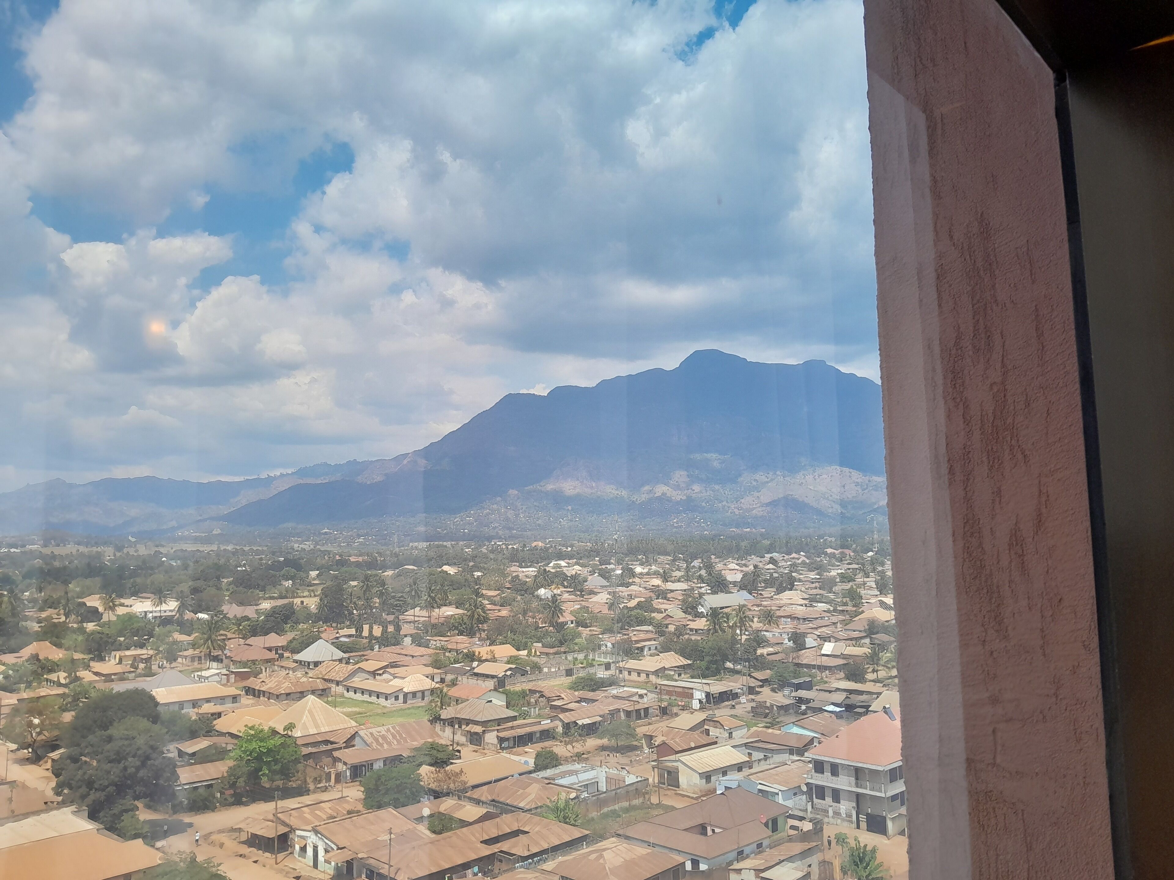 A view of a town with houses and mountains in the background.