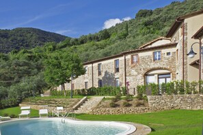 A stone building with a pool and outdoor seating. - Tiglio Grillo (Camaiore)