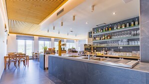 A modern bar area with a marble counter, shelves of liquor bottles, and glassware. - Wellness penzion Lázně Kvilda (Kvilda)