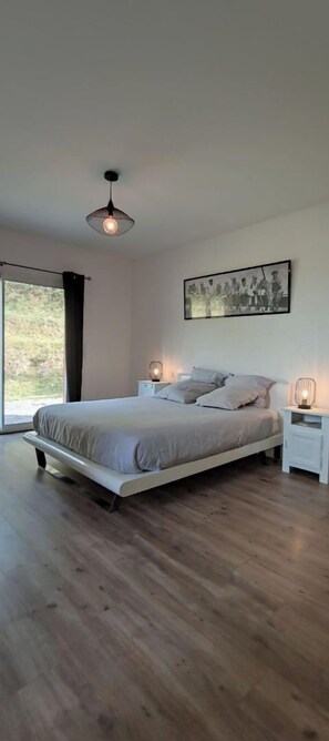 Relax in this serene bedroom with a large bed, bedside tables, and a large window.