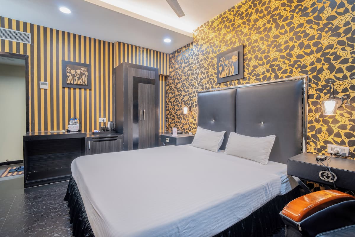 Una habitación de hotel moderna con una cama grande, un armario, una tocador con espejo y una pared con diseño.