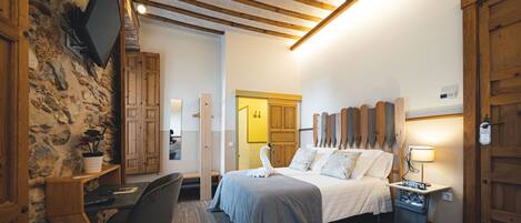 A bedroom with a bed, bedside table, lamp, and a small table with a book.