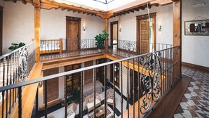A spacious atrium with a high ceiling, wooden beams, and a glass skylight. - La casa del médico - Hostería rural (Urda)