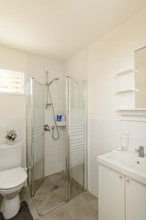 Standaard appartement | Badkamer | Een douche, handdoeken