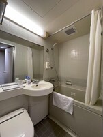 Un baño pequeño y limpio con inodoro, lavabo y ducha.
