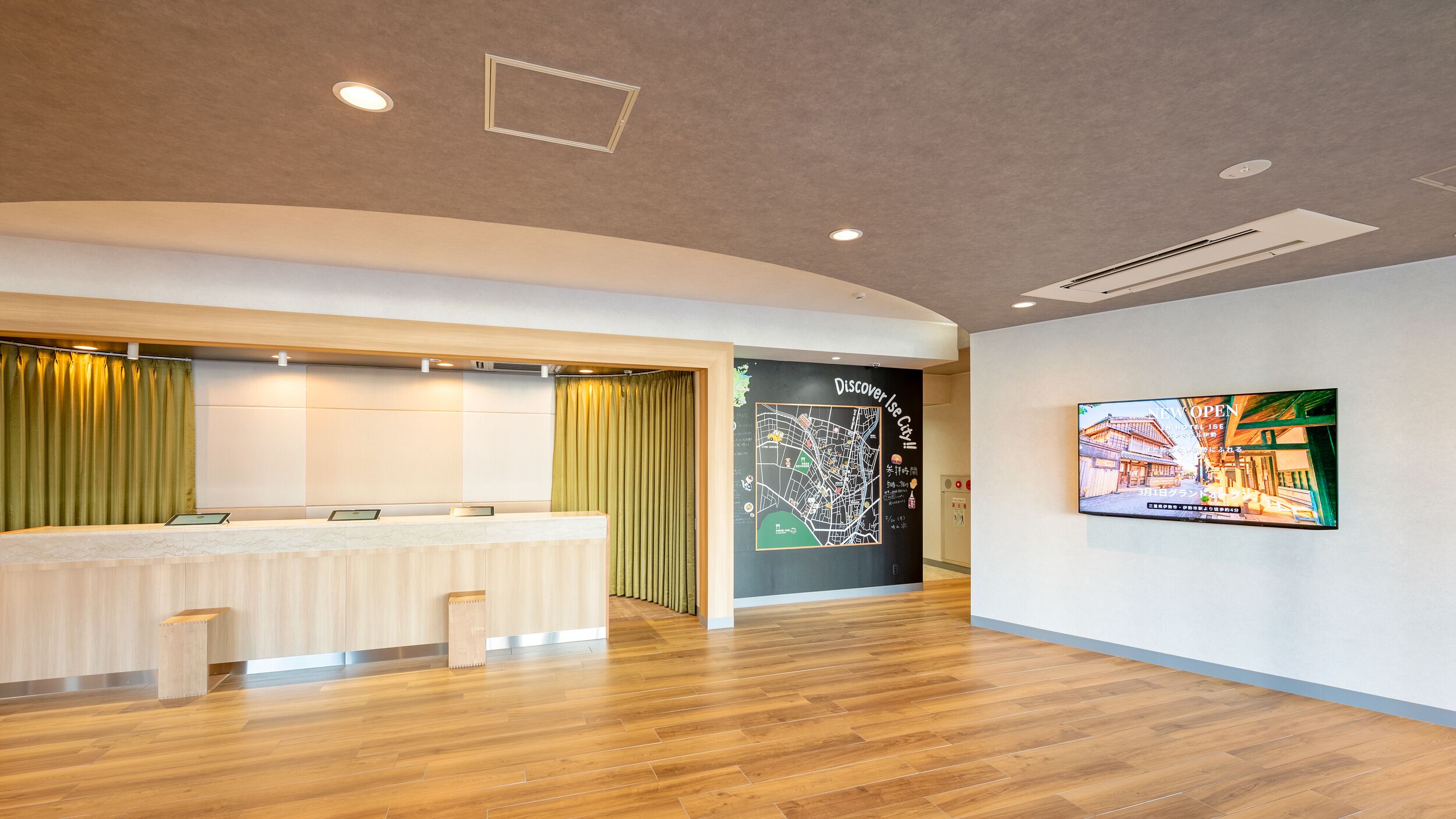 A reception area with a reception desk, a map on the wall, and a television screen displaying a cityscape.