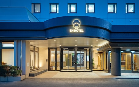 The EN HOTEL entrance with a glass door, a circular logo, and a modern design.