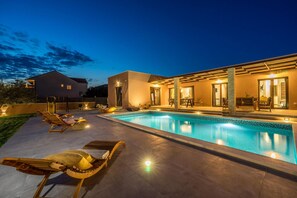 A modern house with a swimming pool, lounge chairs, and a patio area. - Villa Skyfall Zadarvillas (Bibinje)
