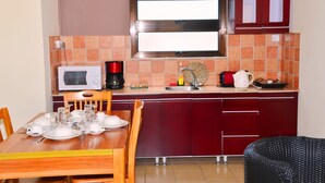 A compact kitchen with a microwave, coffee maker, and a sink.