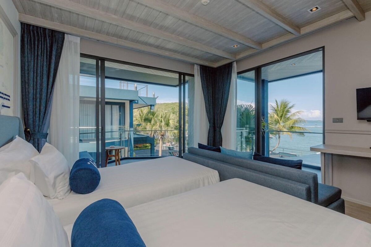 Een moderne hotelkamer met twee bedden, een balkon en een televisie.