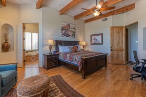 A bedroom with a wooden bed, two bedside tables with lamps, a large window, and a door leading to another room. - Golf Colony w/Golf, Mt & City Views: Salt H2O Pvt POOL, Spa, Kiva Fireplace, TVs All BRs (Mesa)