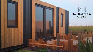 Un edificio moderno in legno con ampie finestre e un recinto in legno.