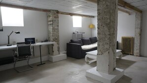 A room with a desk, a couch, and a large pillar. - Charming town house very close to Paris. (Pantin)
