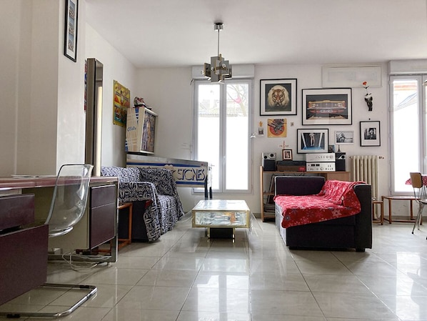 A living room with a sofa, a coffee table, a TV, and a bookshelf.