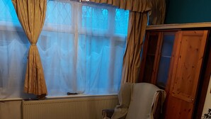 A room with a bed, a chair, a radiator, a window with curtains, and a wooden wardrobe. - Big Lux Double Family room all Modern house. (Wembley)