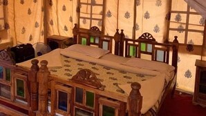 A tent-style room with a bed, wooden headboard, and patterned curtains. - Riddhi Siddhi Resort (Jaisalmer)