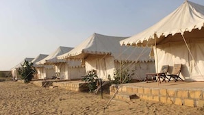 A row of white tents with a flat roof, arranged in a line on a sandy surface. - Riddhi Siddhi Resort (Jaisalmer)