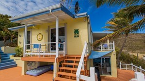 Une maison à deux étages dotée d’un balcon, d’une piscine et d’un escalier menant à l’étage supérieur.