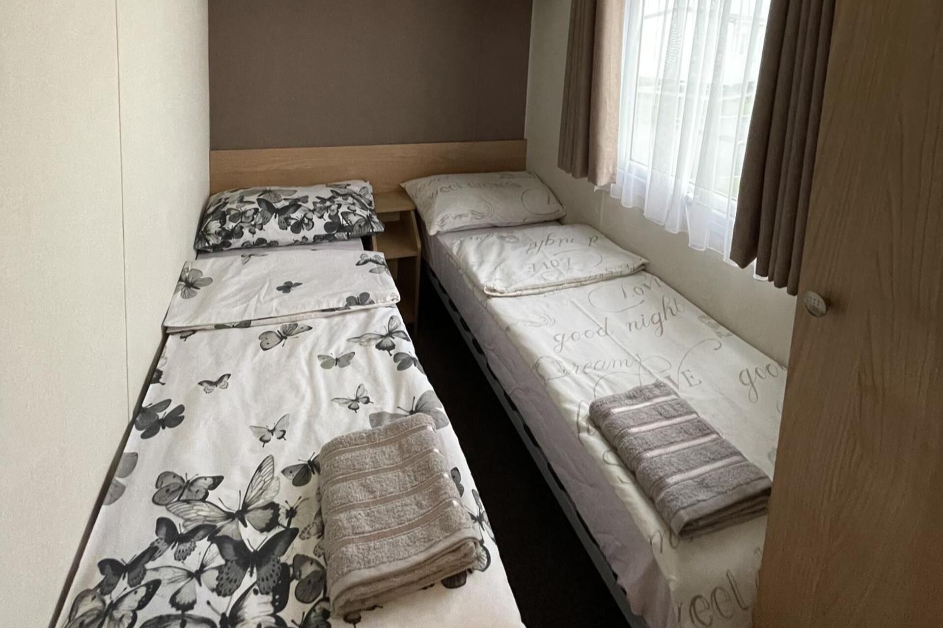 Una habitación con dos camas individuales, cada una con ropa de cama y almohadas de estampado floral.