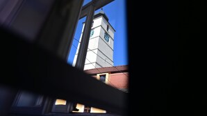 A clock tower with a clear view through a window. - Lovely 2 bedroom apartment in historic city center (Sibiu)