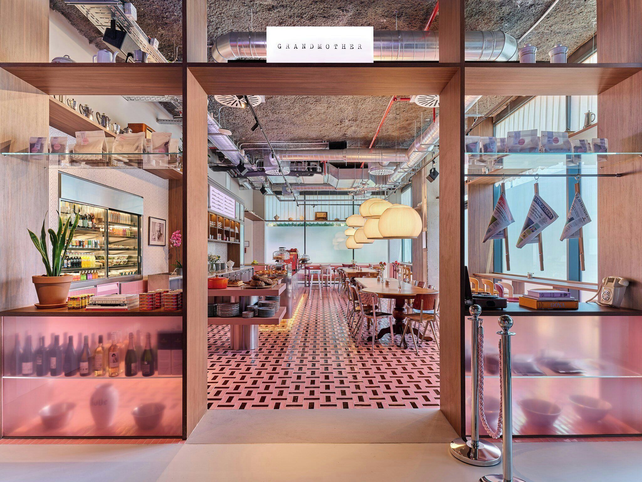 A modern interior with a central walkway, glass display cases, and a sign reading 'GRANDMOTHER'.
