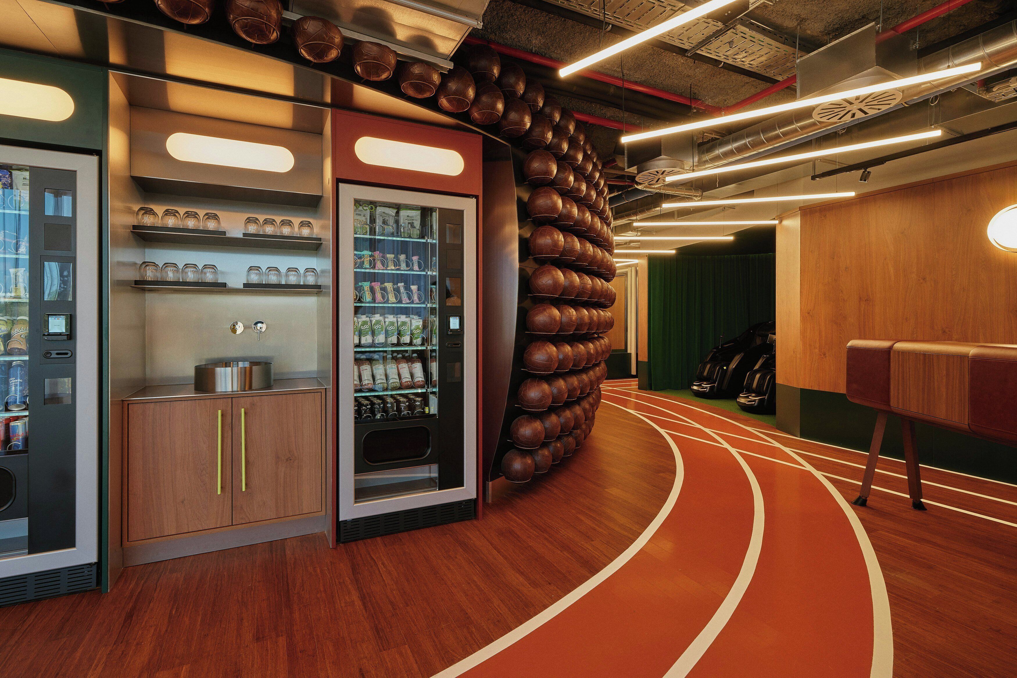 A modern interior with a vending machine, a wooden cabinet, and a wall of spherical objects.