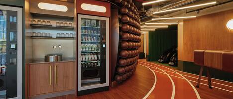 A modern interior with a vending machine, a wooden cabinet, and a wall of spherical objects.
