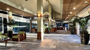 Eine großzügige Lobby mit hoher Decke, Steinböden und großen Fenstern.