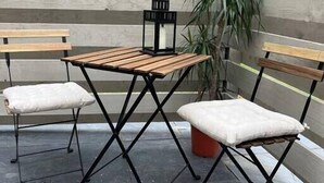 A wooden table with two chairs, a black lantern, and a potted plant in an outdoor setting. - Cosy Wrekin View Annexe (Eaton Constantine)