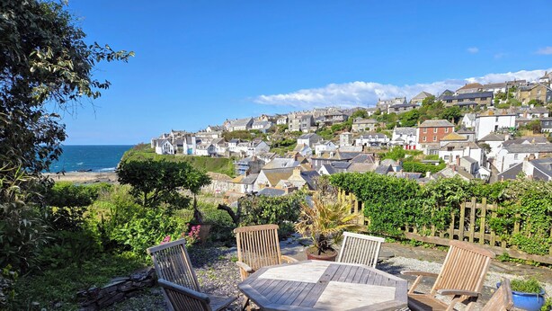 A patio with wooden furniture overlooking a coastal town. - A beautiful renovated Georgian house minutes walk to Port Isaac's harbourside (Port Isaac)