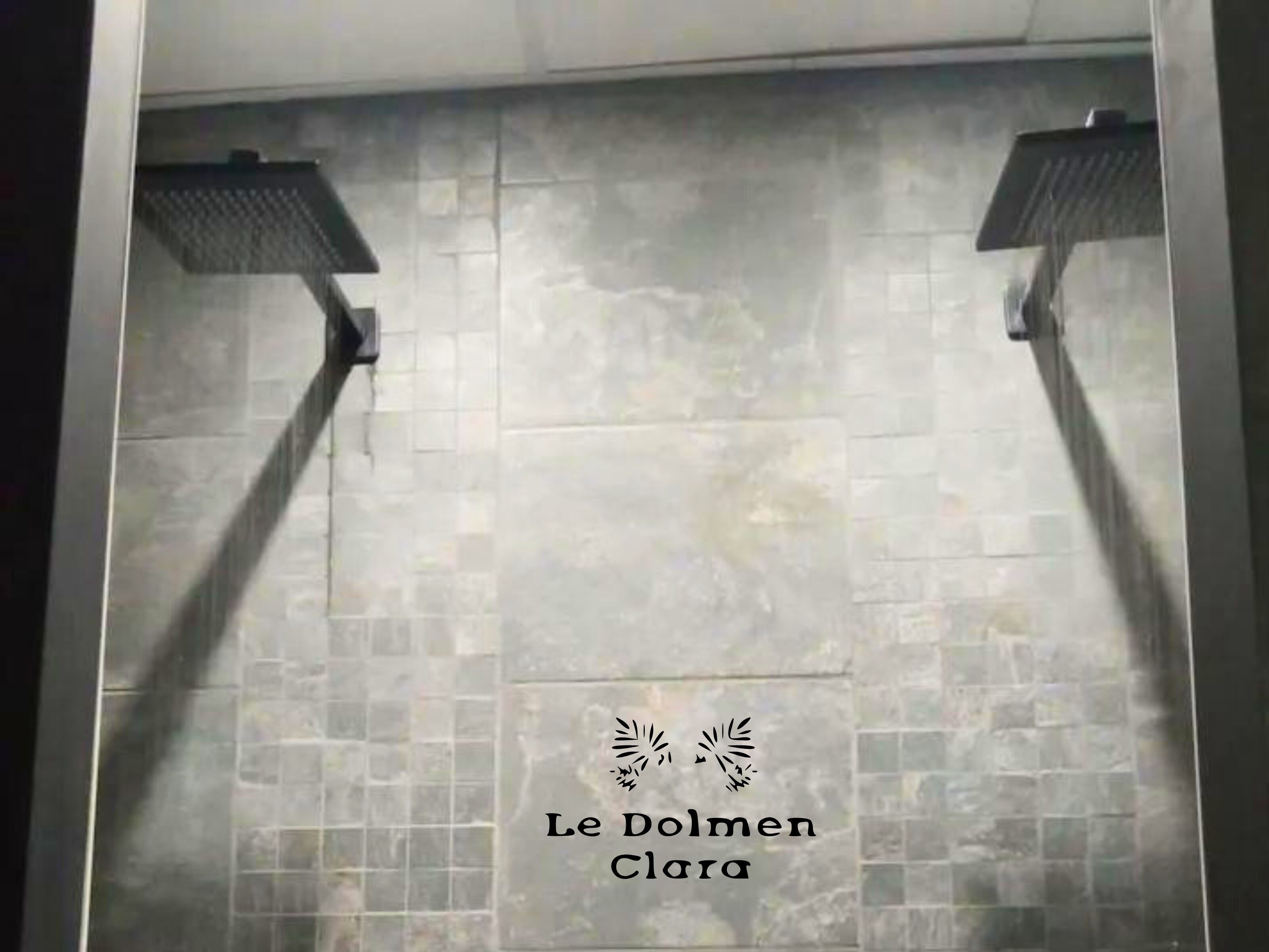 A tiled shower area with two overhead shower heads.