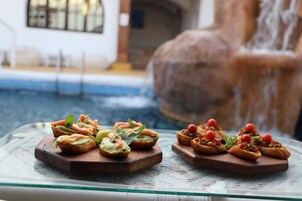 Una piscina al aire libre, sombrillas, tumbonas