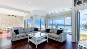 Relax in this stylish living area with a large sectional sofa, coffee table, and dining table.