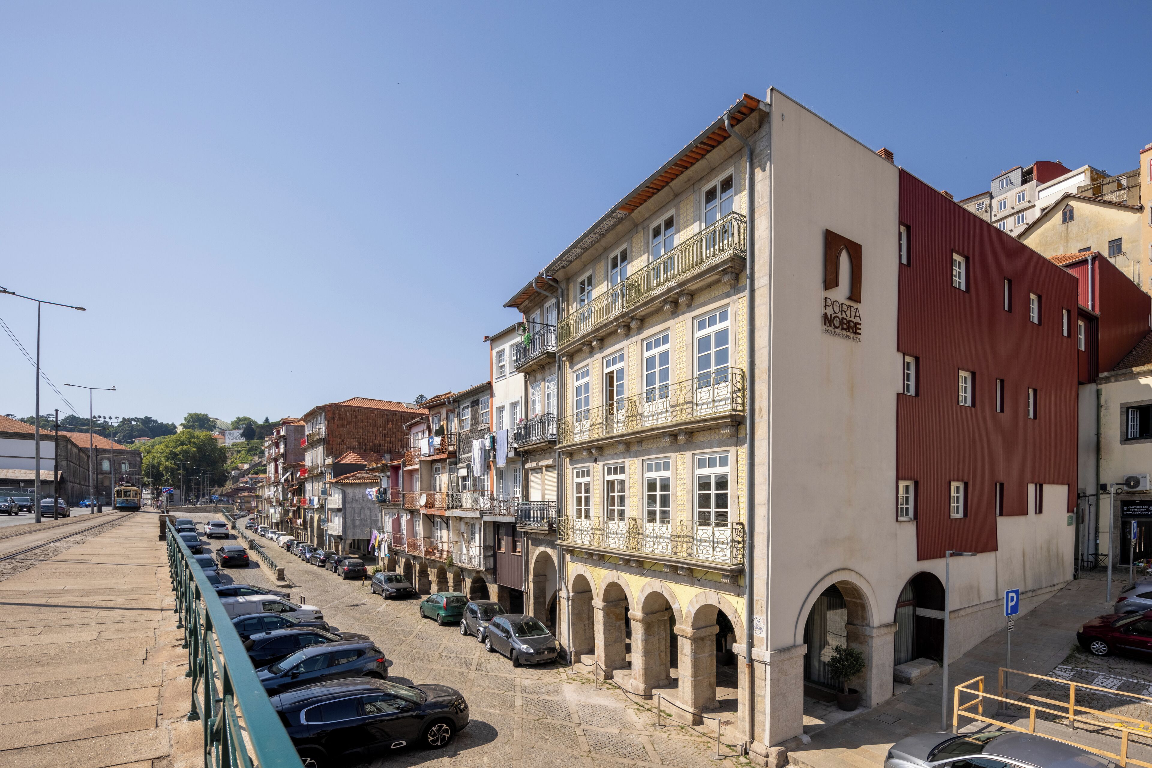 A row of buildings with balconies and a tram line.