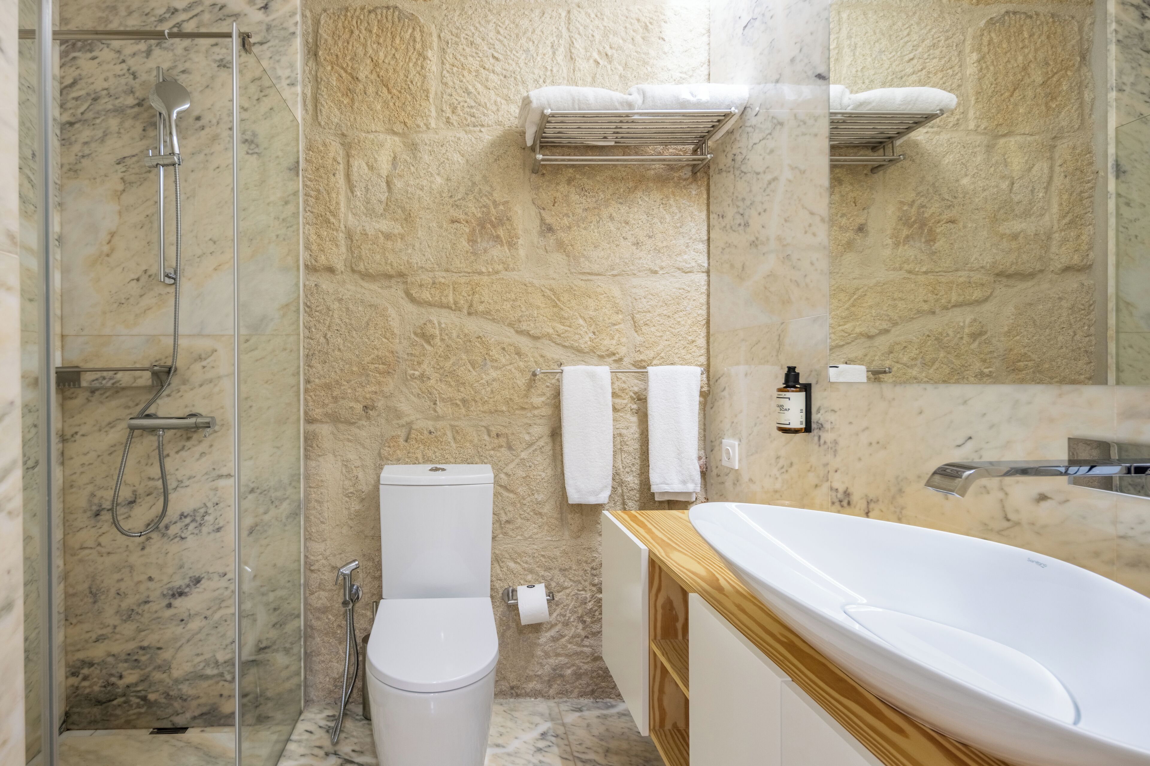 Un baño con ducha de vidrio, inodoro, lavamanos y bañera.