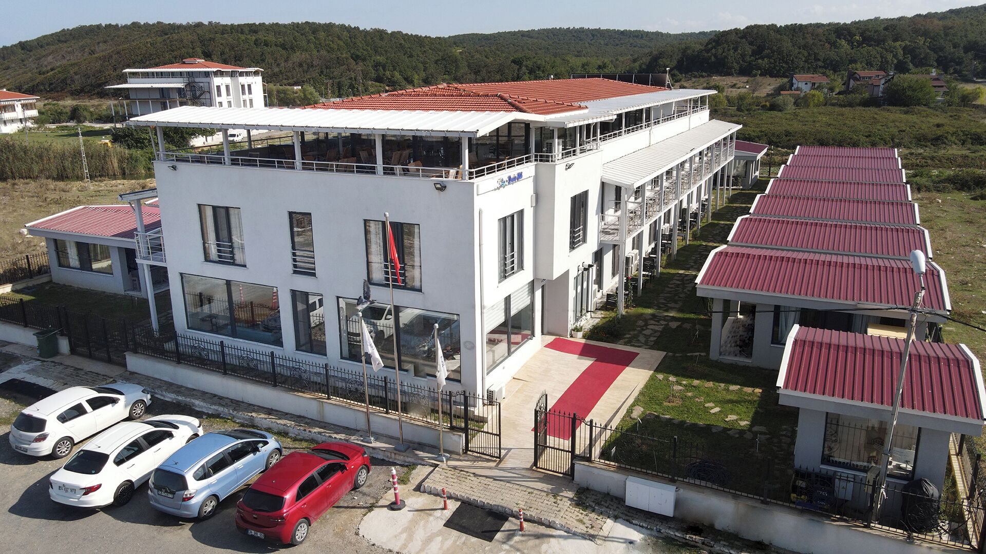 Un immeuble à plusieurs étages, doté d’un toit rouge, de grandes fenêtres et d’un espace extérieur abrité.