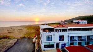 A coastal building with multiple balconies overlooking the beach and ocean. - YALIKÖY DENİZ OTEL (Catalca)