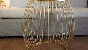 A room with a light blue sofa, a gold wire table, and a wall art piece. - Studio με θέα θάλασσα και ουρανό!! (Gytheio)
