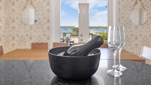 A black bowl with a spoon on a table, a wine glass, and a view of a lake through a window. - Waterfront Home w Patio, Heated Pool, Dock, Beach (St. Augustine)
