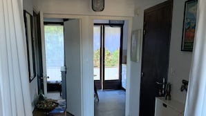 A hallway with wooden flooring, a door leading to a balcony, and a ceiling-mounted light fixture. - The Isard appt (Vernet-les-Bains)
