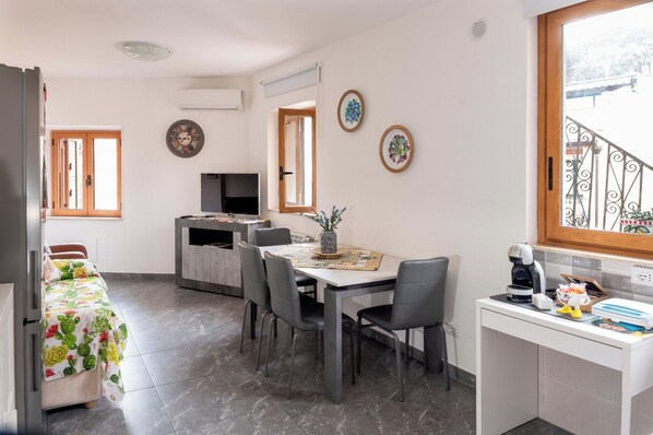A compact living space with a dining area, kitchenette, and a small balcony. - Vacation Home Sleeping 3, 200 Meters from the Center of Taormina (Taormina)