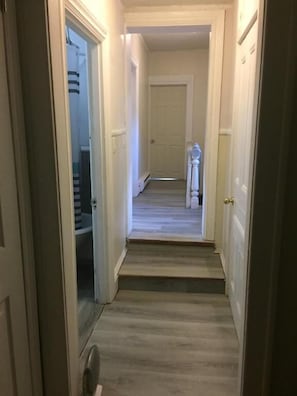 Leading to a space, this hallway offers a simple, clean design with a carpeted floor.
