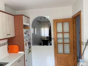 Kitchen area with refrigerator, window, and mirror.