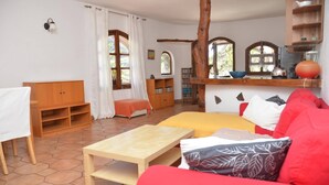 A cozy living room with a red sofa, a wooden table, and a bookshelf. - Casa Corma (Valle Gran Rey)