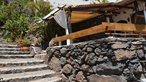 A stone staircase leading to a wooden porch with a tiled roof. - Casa Corma (Valle Gran Rey)