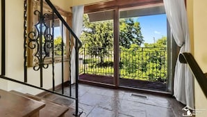 Un escalier menant à un balcon d’où l’on peut admirer un jardin.