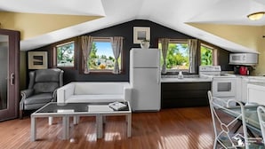 Un appartement moderne de style « loft » comprenant une cuisine, un coin repas et un salon.